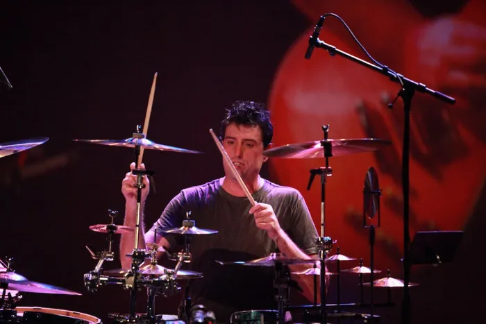 Steve Joslin playing drums under warm stage lights