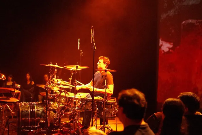 Steve Joslin at the drum kit with projected visuals behind him