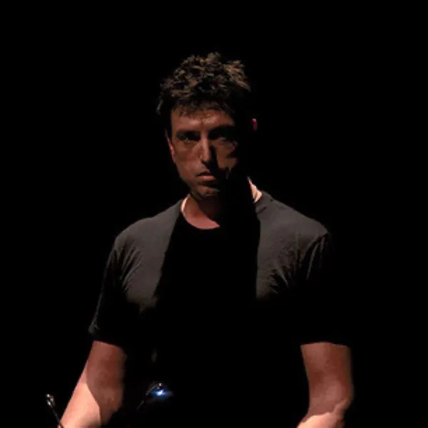 Portrait of Steve Joslin lit from one side against a black background